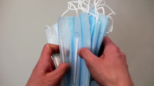 A Pack of Medical Disposable Masks in the Hands of a Man Close Up