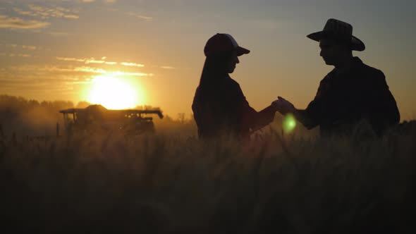 Farmers Handshake Over the Wheat Crop in Harvest Time. Team Farmers Stand in a Wheat Field with