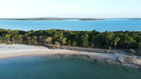 Panning drone view of a narrow coastal peninsular dividing an expansive lake and ocean inlet holiday