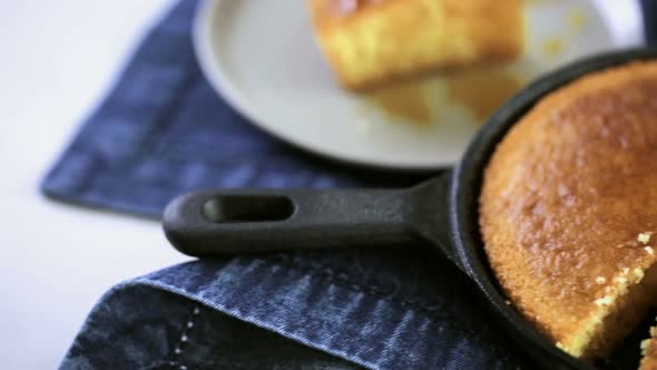 Slice of sweet cornbread with honey on the plate