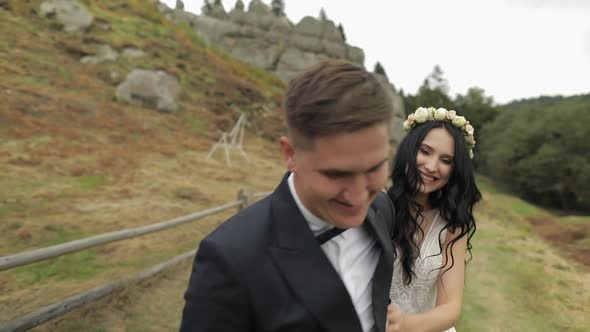 Groom with Bride Walking Near Mountain Hills. Wedding Couple in Love