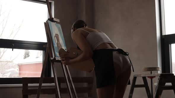 Woman Painting on Easel in Workshop