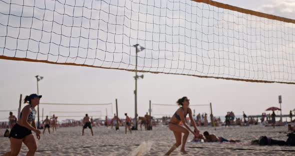 Slow motion of women playing beach volleyball during sunset