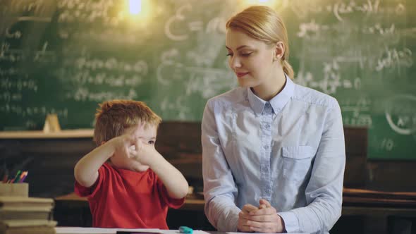 Kid in School. Smiling Mother Helping Son with Homework at Home.