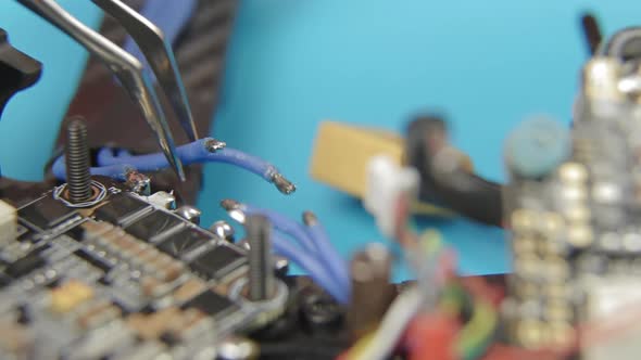 Soldering ESC Contacts. Extreme Close Up of Young Man's Hands Assembling FPV Racing Drone.