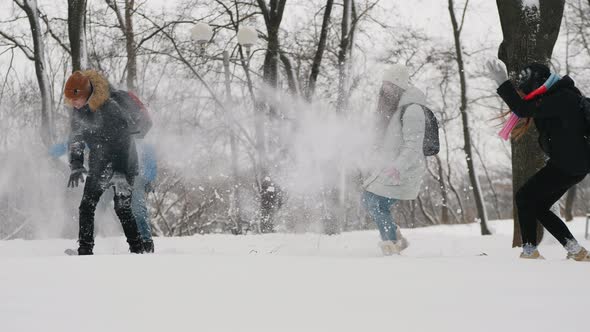 Teens Ave Fun Throwing Snow at Each Other in City Park