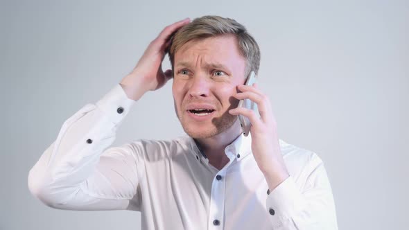 Man Reacting to Loss While Talking on Phone White Background