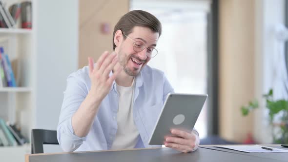Man in Glasses Making Video Call on Tablet in Office