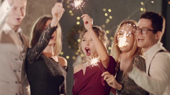 Asian Girl and Group Young College Student Friends Lit Light Sparkler in Hand Fireworks Sing and