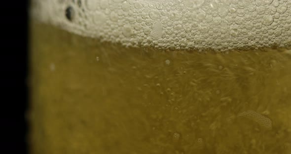 Pouring Cold Golden Light Beer Into a Glass. Craft Beer Making Bubbles and Foam