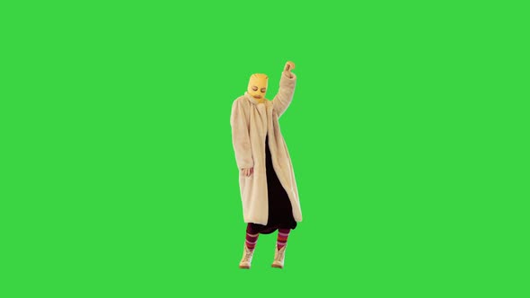 Young Daring Girl in Coat and Balaclava Dancing on a Green Screen Chroma Key