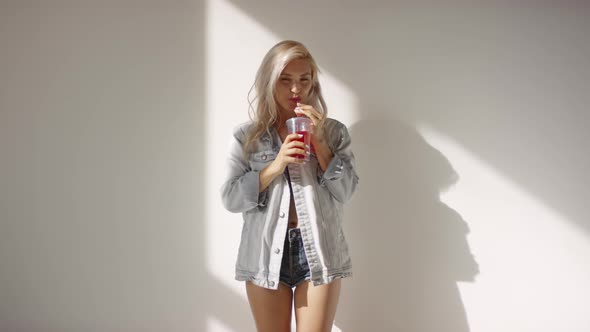 Blonde Caucasian Model Drinking through Straw and Posing