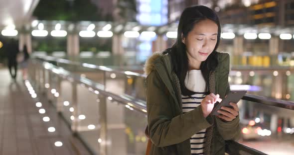 Woman use of smart phone in city at night