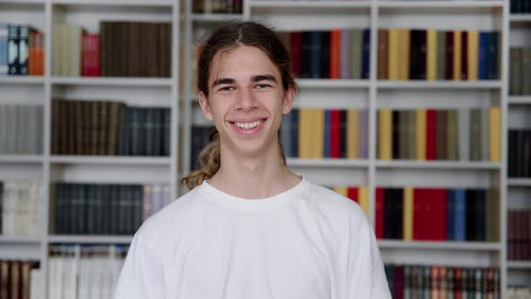 Single Portrait of Smiling Confident Male Student Teenager Looking at Camera in Library