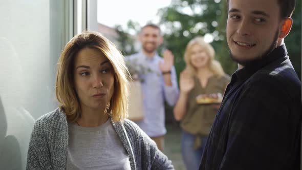 Young European Couple Waiting for Their Neighbors To Leave