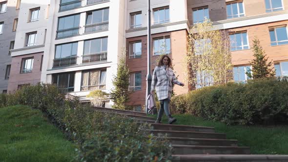 Attractive Girl of European Appearance Walks Down the Street Smiling