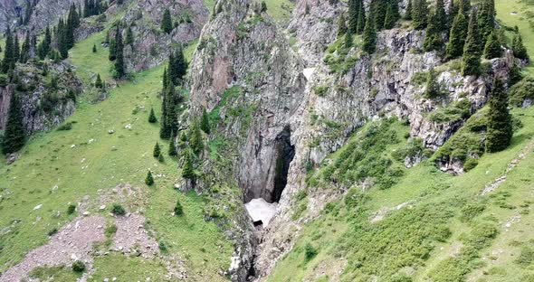 Black Waterfall in a Gorge with an Ice Cave.