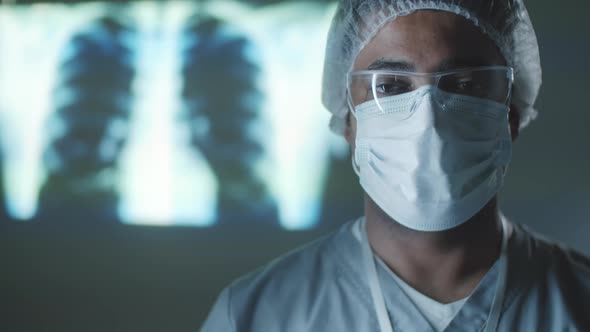 Portrait of Male Doctor in Protective Uniform in Dark Lab