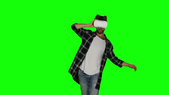 Man in VR Mask Passes Some of Virtual Obstacles, Green Screen