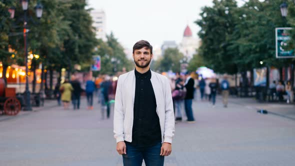 Time-lapse Portrait of Young Man Student Standing Alone in the Street in Big City Looking at Camera