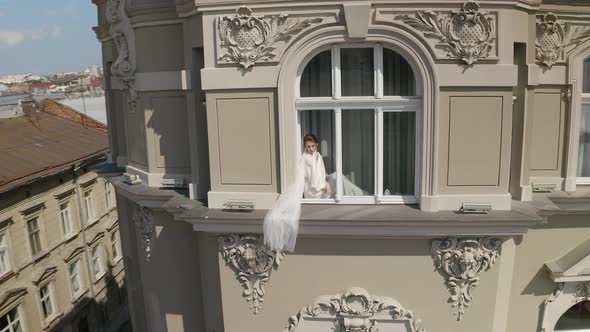 Bride in Boudoir Dress Sitting on Window Sill Wedding Morning Preparations Woman in Night Gown Veil