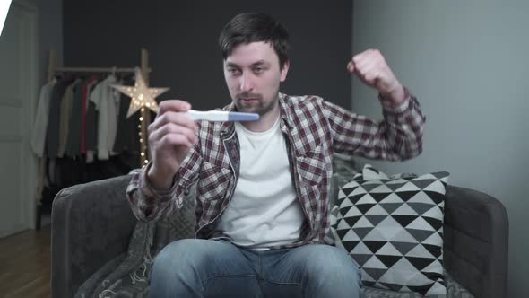 Future Young Father is Very Happy About News of Pregnancy Holds Pregnancy Test and is Incredibly