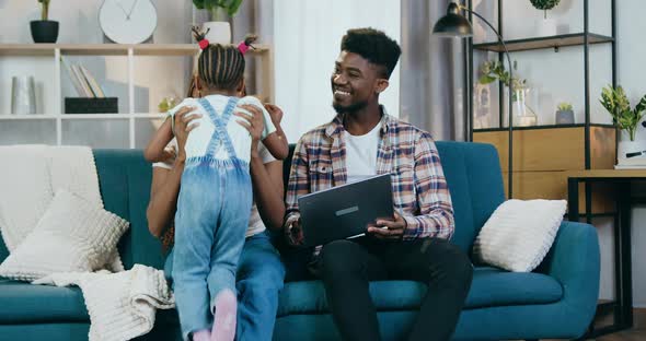 Smiling African Family Watching Videos on Laptop at Home