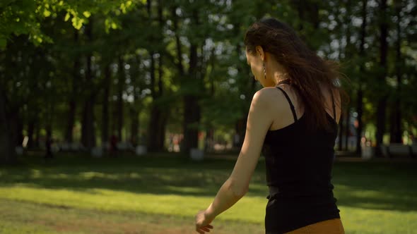 Smiling Young Lady Walking at the Park Outdoors Talking By Phone