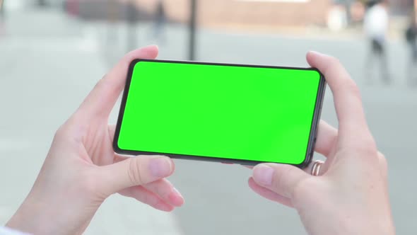 Woman Looking at Smartphone with Green Chroma Screen