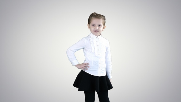 Little smiling girl in white poses on gradient background.
