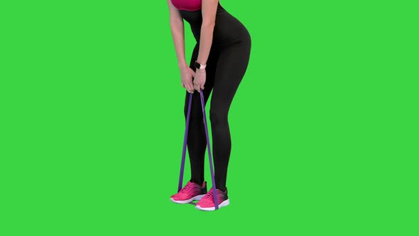 Woman Training Latissimus with a Rubber Resistance Band on a Green Screen Chroma Key