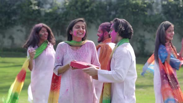 Indian man gifting sweets to his partner on Holi occasion