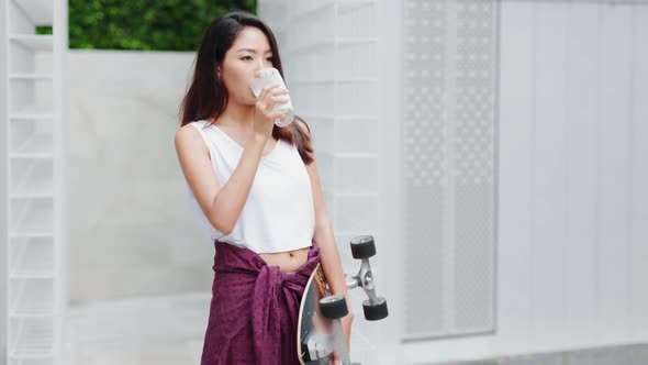 Attractive Asian woman drinking milk and smiling at home close up face.healthy life