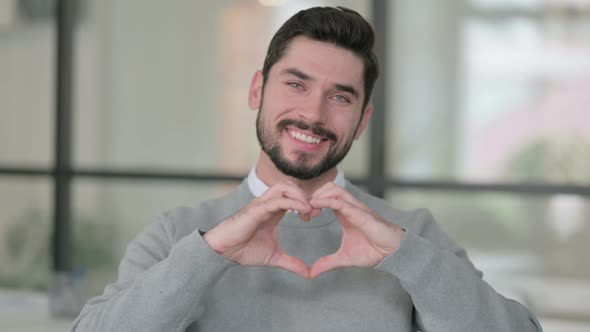 Portrait of Young Man Showing Heart Shape By Hands