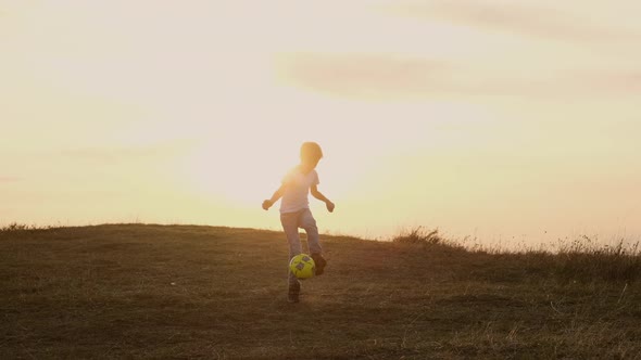 Boy Running After Soccer Ball. Outdoor Recreation. Sky And Horizon.