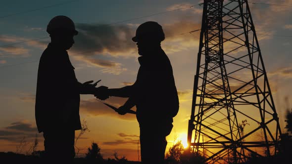 Engineers Shaking Hands at the Construction of Highvoltage Power