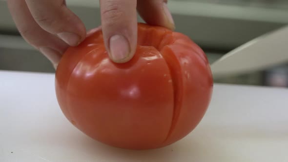 Creatively slicing a beefeater tomato for a salad or meal. Shot in reality series style.