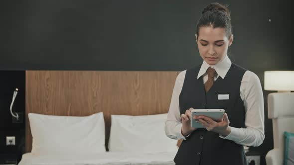 Portrait of Female Manager with Tablet in Hotel Room