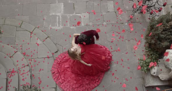 Girl And Guy Stand In Festive Attire And Rose Petals Fly From Above