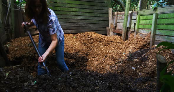 Mature woman using gardening fork in the garden 4k