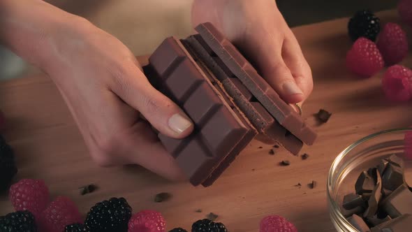 A woman’s hands in close up break up various size of chocolate bars (6 size - 6 shot)