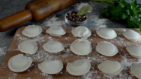Rows of Frozen Raw Pelmeni Dumplings Stuffed with Mince Meat on Cutting Board