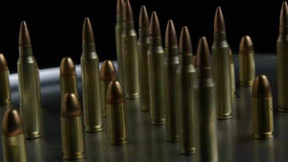 Cinematic rotating shot of bullets on a metallic surface