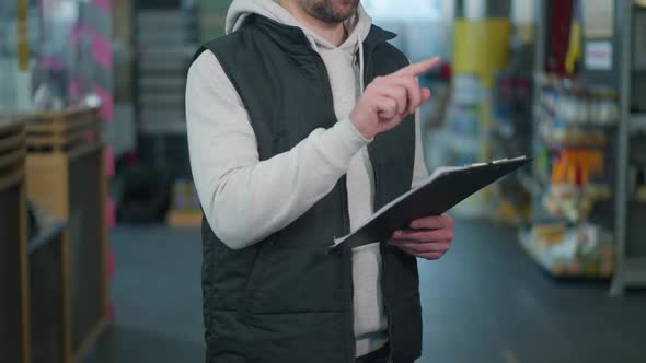 Unrecognizable Caucasian Male Employee Checking Tools and Supplies in Hardware Store