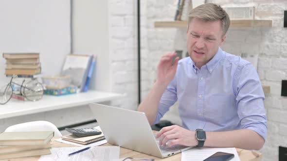 Businessman Having Neck Pain While Working on Laptop