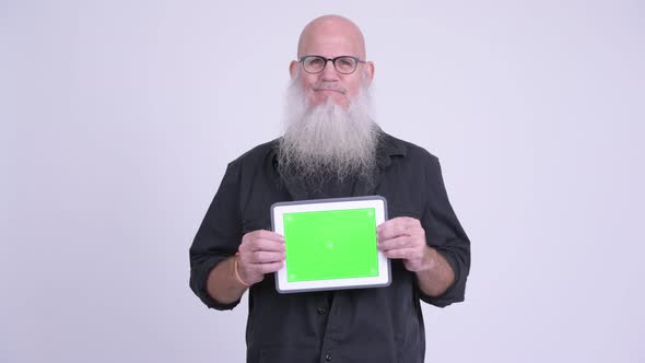 Happy Mature Bald Bearded Man Showing Digital Tablet