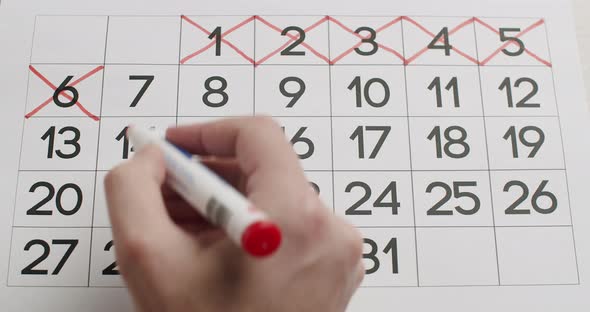 Man's Hand Write Down the 678910Th Day on the Paper Calendar Using a Red Pen