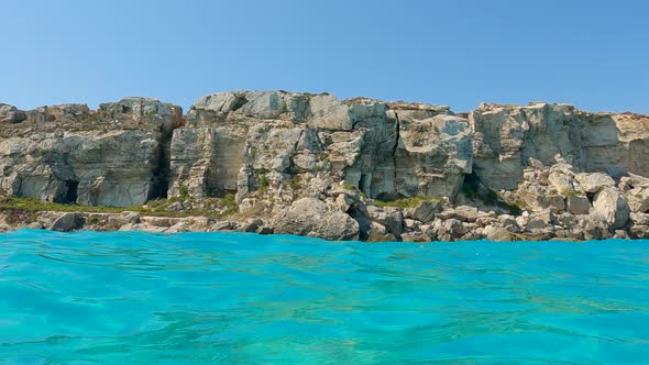 People bathe in turquoise sea water at Favignana island in Sicily, Italy. Water surface pov