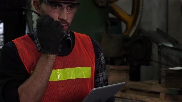 Industrial worker using walkie-talkie radio.