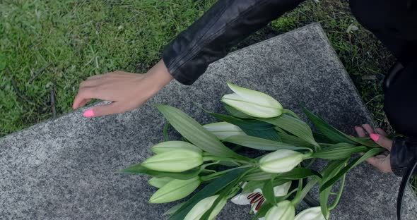 Black Woman Lays Flowers to the Grave Stone and Strokes It